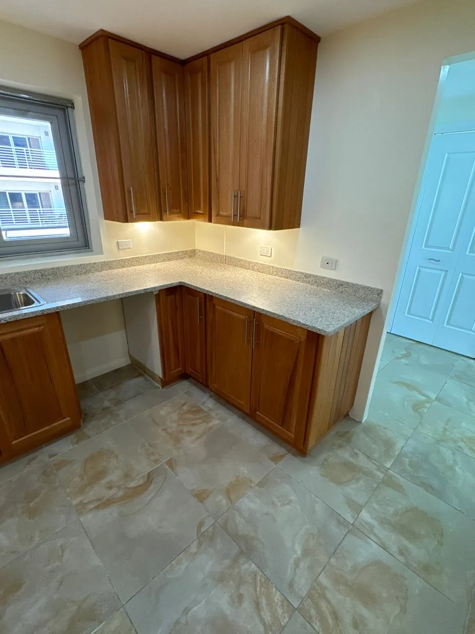 Completed kitchen renovation with timber cabinetry and stone countertops